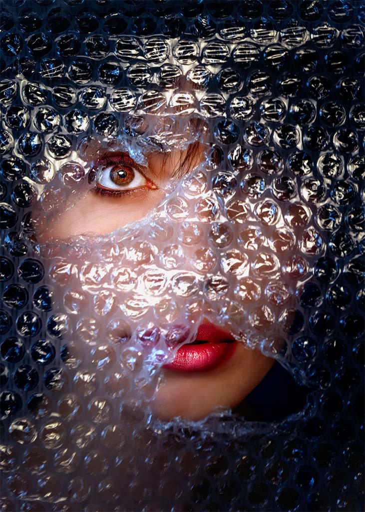 portret twarzy kobiety widziany przez folię bąbelkową