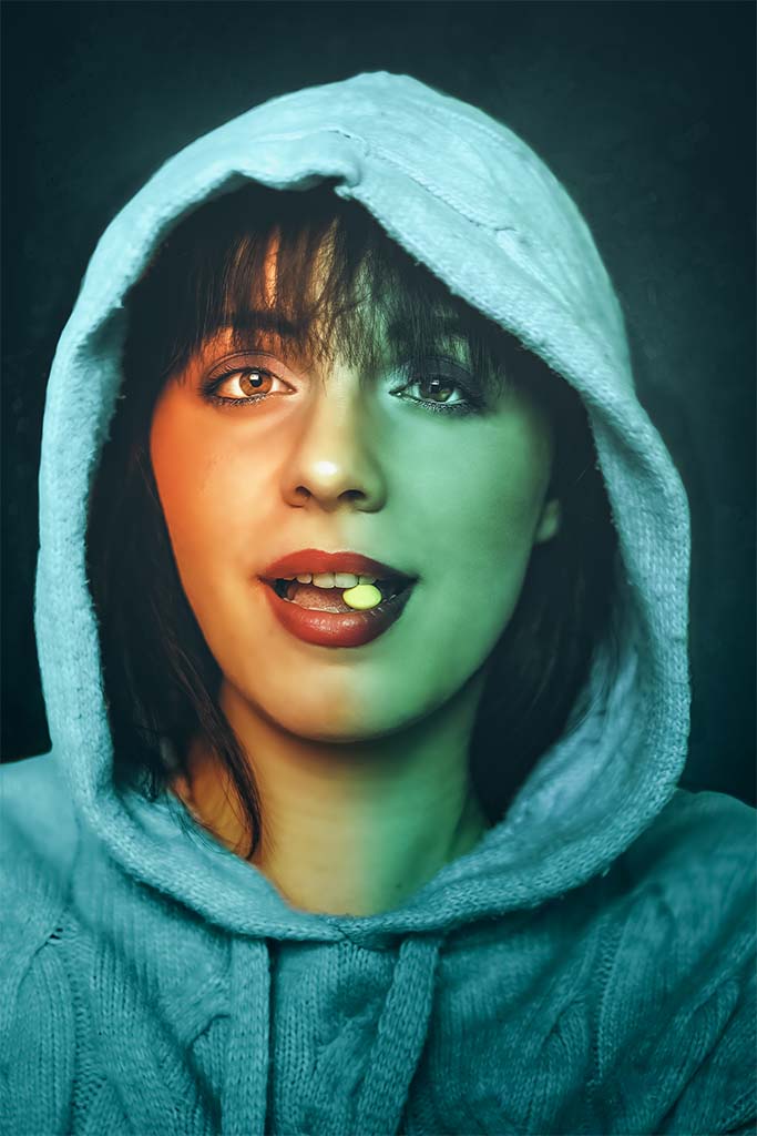 Portret twarzy kobiety w kapturze z cukierkiem w ustach